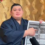 Sumo wrestler Onosato displays the Kyushu banzuke.