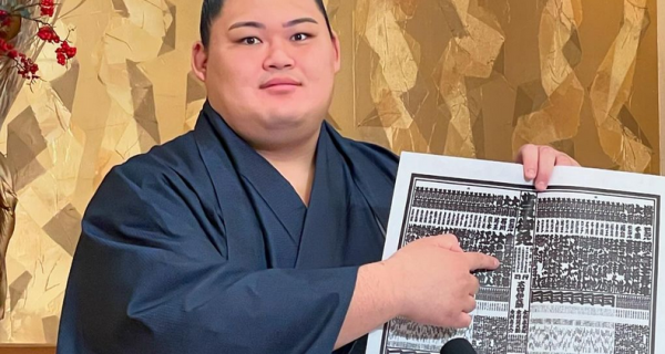 Sumo wrestler Onosato displays the Kyushu banzuke.