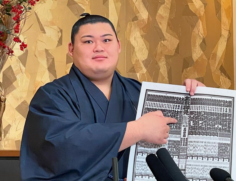 Sumo wrestler Onosato displays the Kyushu banzuke.