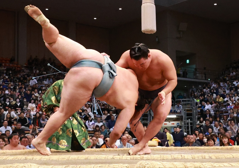 Sumo wrestler Hoshoryu throws down Oshoma at the 2024 Kyushu Basho.