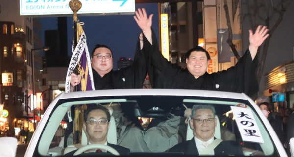 Sumo wrestler Onosato (right) celebrates his championship victory at the 2025 spring tournament in Osaka, Japan.
