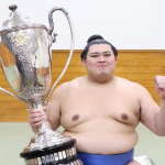 Sumo wrestler Onosato with his trophy after winning the 2025 summer tournament.