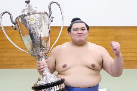 Sumo wrestler Onosato with his trophy after winning the 2025 summer tournament.