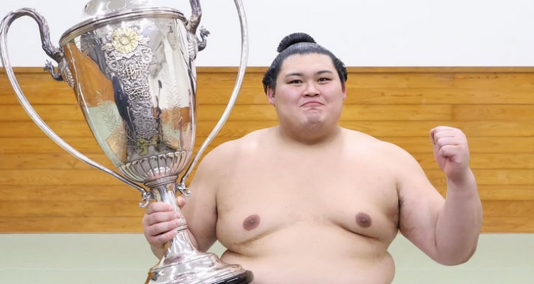 Sumo wrestler Onosato with his trophy after winning the 2025 summer tournament.