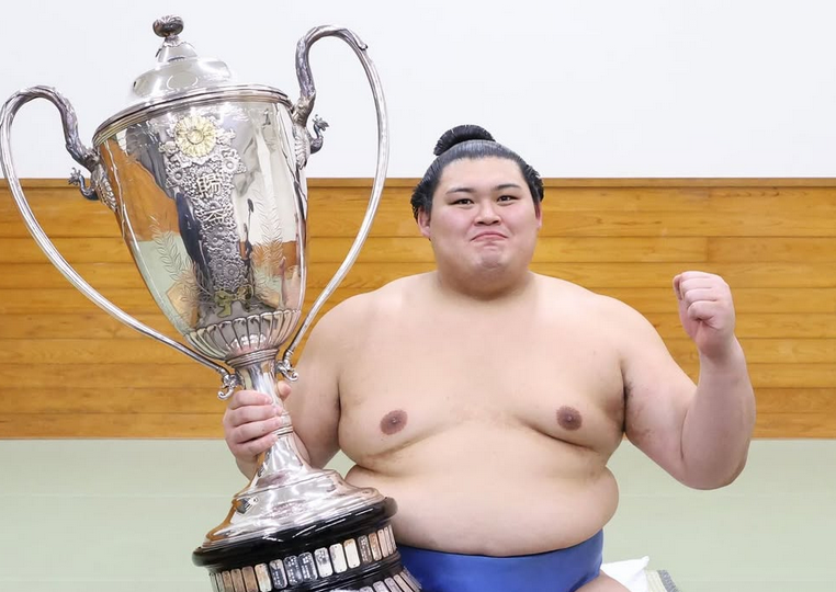 Sumo wrestler Onosato with his trophy after winning the 2025 summer tournament.