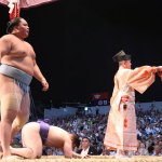 Sumo wrestler Kotoshoho stands over Aonishiki after he won the 2025 Nagoya basho.