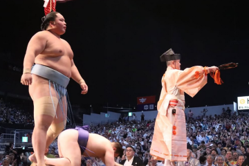 Sumo wrestler Kotoshoho stands over Aonishiki after he won the 2025 Nagoya basho.