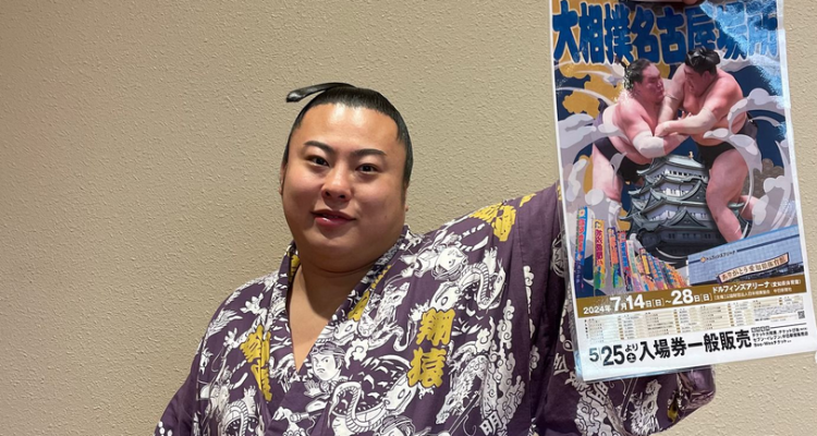 Sumo wrestler Tobizaru shows off a program for the 2024 Nagoya basho.