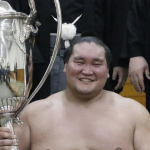 Sumo yokozuna Terunofuji celebrating with the Emperor's Cup after his win at the 2024 Nagoya basho.