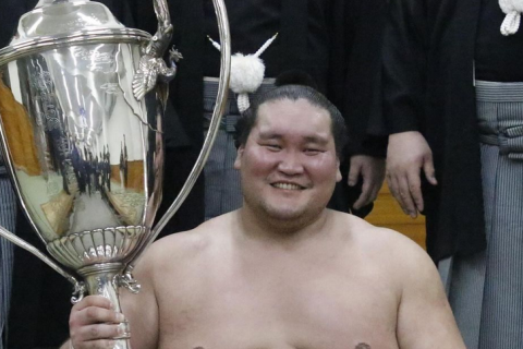 Sumo yokozuna Terunofuji celebrating with the Emperor's Cup after his win at the 2024 Nagoya basho.