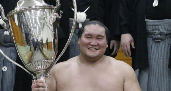 Sumo yokozuna Terunofuji celebrating with the Emperor's Cup after his win at the 2024 Nagoya basho.