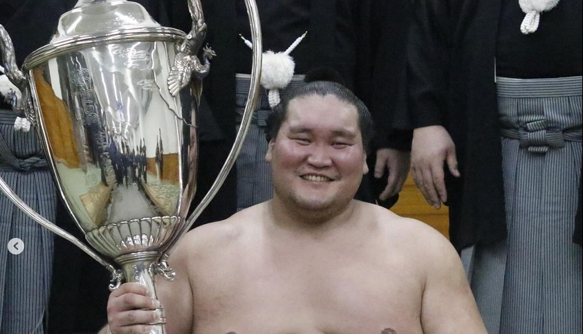 Sumo yokozuna Terunofuji celebrating with the Emperor's Cup after his win at the 2024 Nagoya basho.